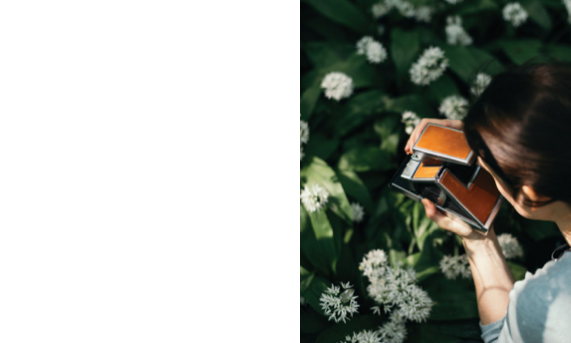 A woman using a folding camera to take a picture